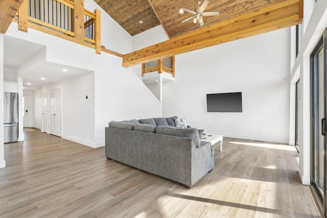 living room featuring high vaulted ceiling, light hardwood / wood-style flooring, and wooden ceiling