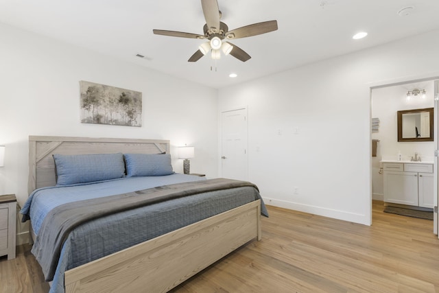 bedroom with ceiling fan, sink, ensuite bathroom, and light wood-type flooring