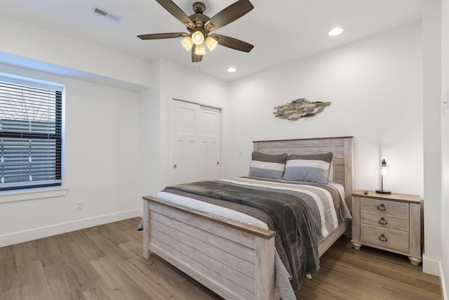 bedroom with hardwood / wood-style flooring, a closet, and ceiling fan