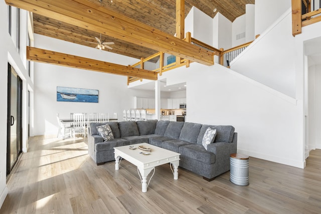 living room featuring hardwood / wood-style floors, ceiling fan, and a high ceiling