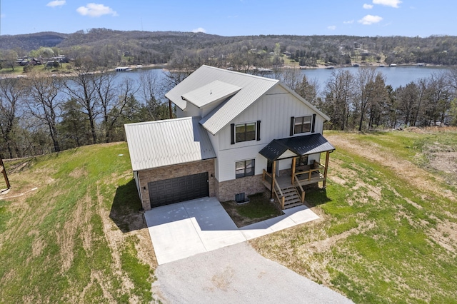 view of front of property with a garage, a water and mountain view, and covered porch