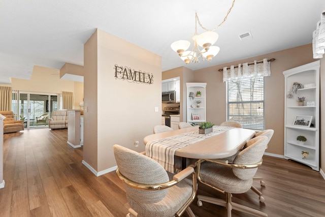 dining area featuring hardwood / wood-style floors and a chandelier