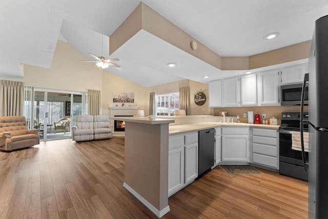 kitchen with a wealth of natural light, stainless steel appliances, kitchen peninsula, and white cabinets