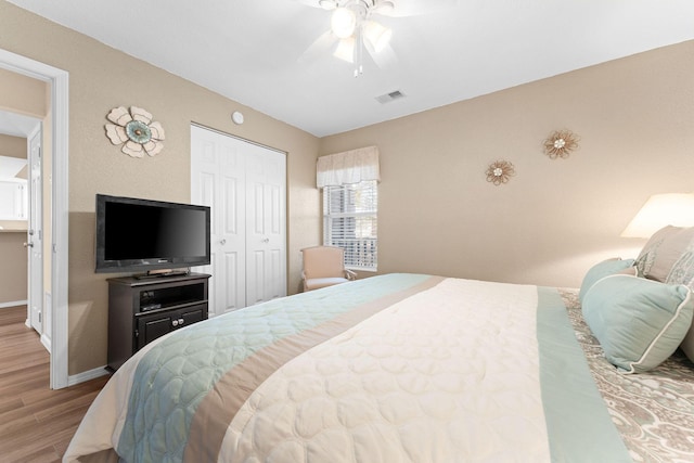 bedroom featuring hardwood / wood-style floors, ceiling fan, and a closet