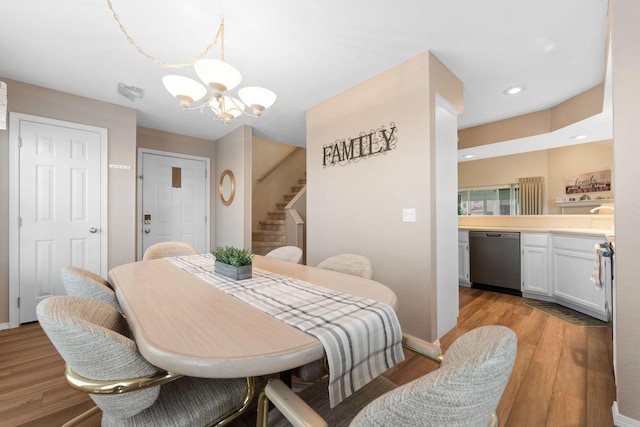 dining area with light hardwood / wood-style floors and a notable chandelier