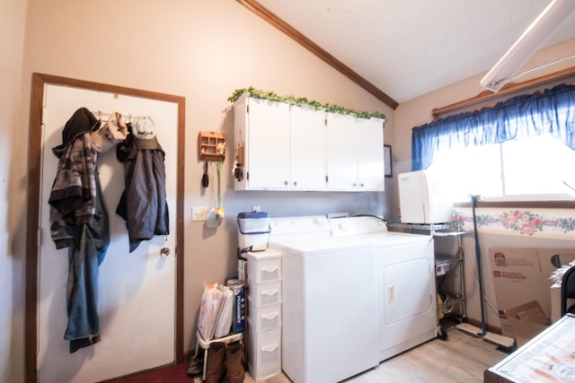 laundry area featuring independent washer and dryer, light hardwood / wood-style flooring, and cabinets