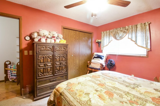 carpeted bedroom with a textured ceiling, a closet, and ceiling fan