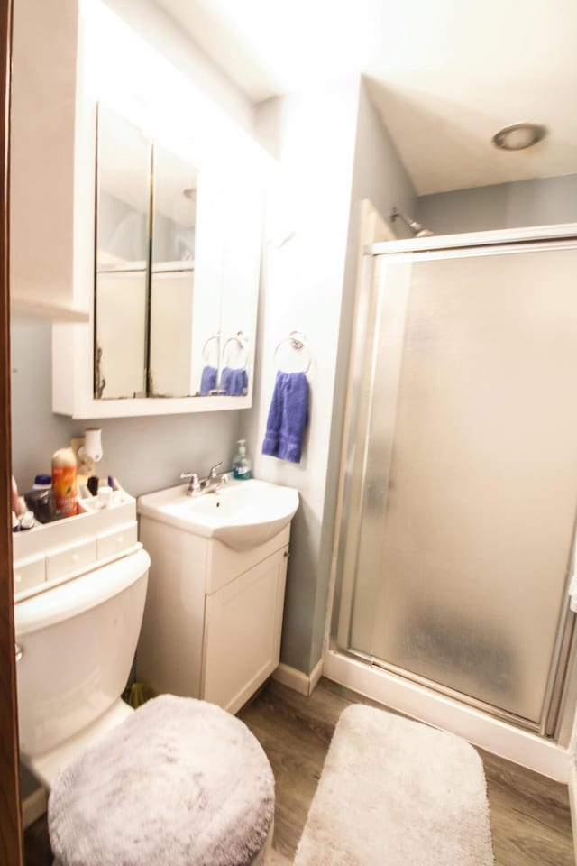 bathroom with vanity, hardwood / wood-style flooring, toilet, and walk in shower