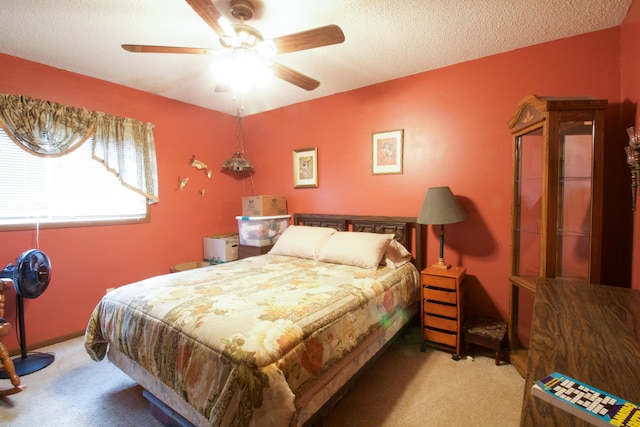 carpeted bedroom featuring ceiling fan and a textured ceiling