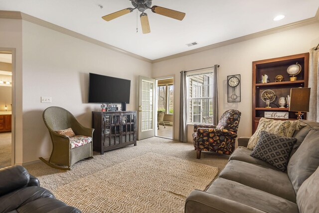 carpeted living room featuring ornamental molding and ceiling fan