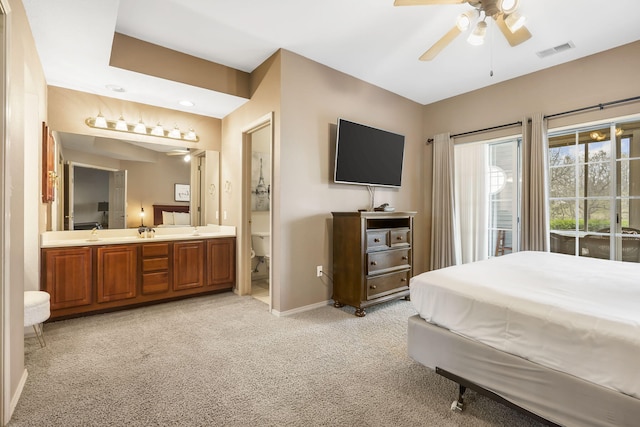 carpeted bedroom with sink, access to outside, ceiling fan, and ensuite bathroom