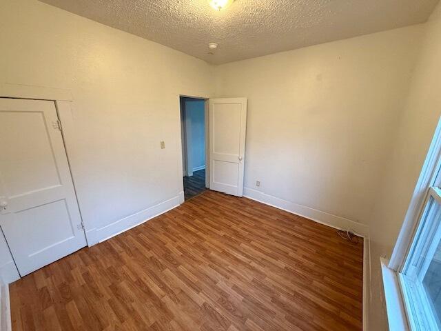 unfurnished bedroom with hardwood / wood-style flooring and a textured ceiling