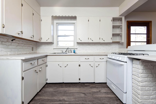 kitchen featuring a healthy amount of sunlight, white gas range, sink, and white cabinets