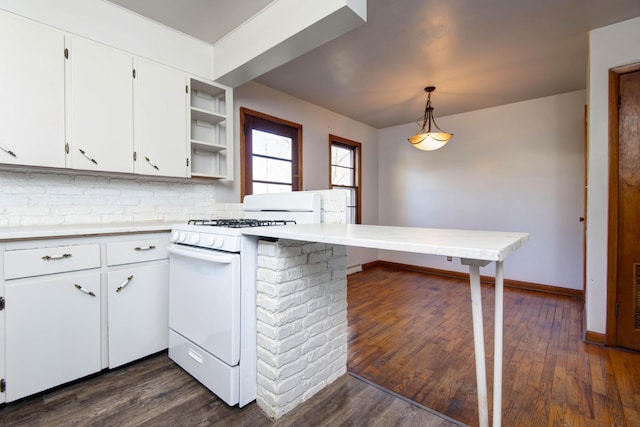 kitchen with kitchen peninsula, white gas stove, white cabinets, and decorative light fixtures