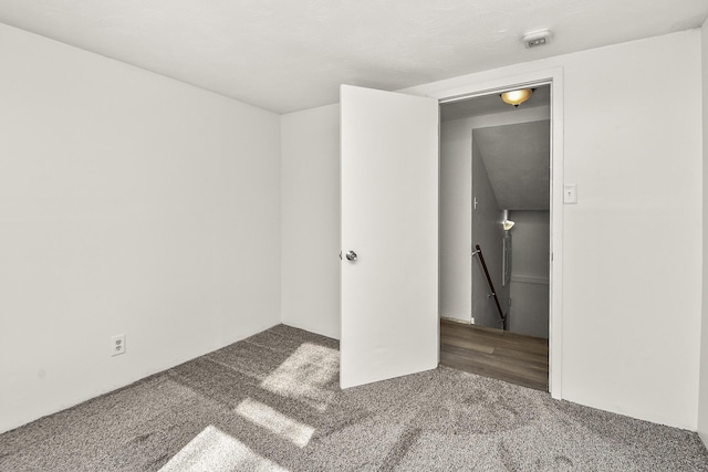 unfurnished bedroom with dark colored carpet