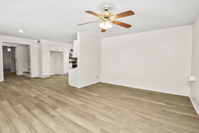 unfurnished living room featuring ceiling fan and light hardwood / wood-style flooring