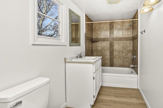 full bathroom featuring vanity, toilet, hardwood / wood-style floors, and tiled shower / bath