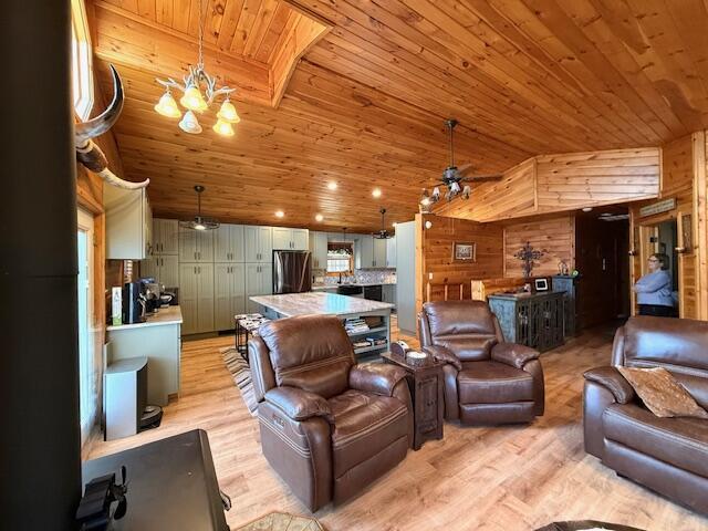 living room featuring lofted ceiling, wood ceiling, light hardwood / wood-style floors, and wood walls