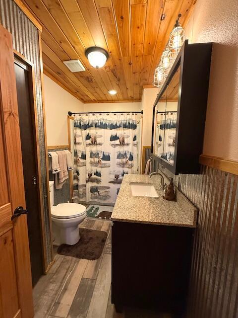 bathroom featuring hardwood / wood-style floors, curtained shower, vanity, toilet, and wooden ceiling