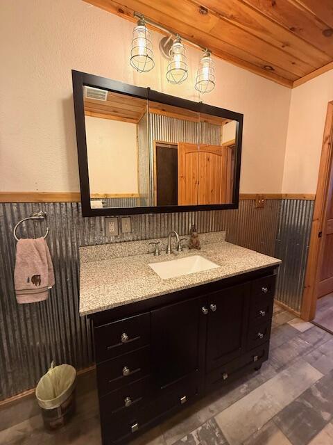 bathroom with hardwood / wood-style flooring, vanity, wooden walls, and wooden ceiling