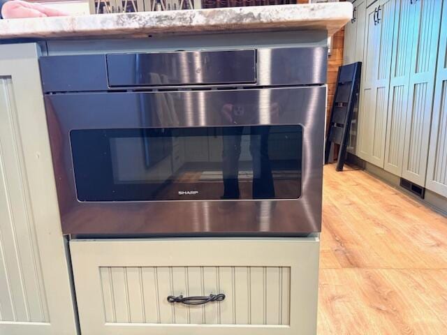 interior details with wall oven and light hardwood / wood-style flooring