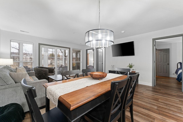 dining area with hardwood / wood-style flooring and a notable chandelier