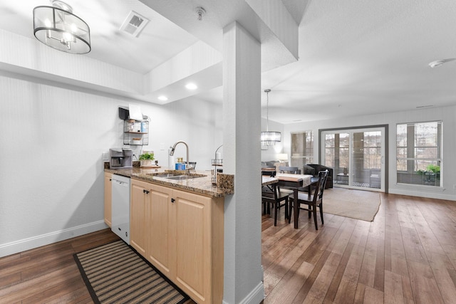 kitchen featuring sink, dark wood-type flooring, a notable chandelier, light brown cabinetry, and dark stone counters