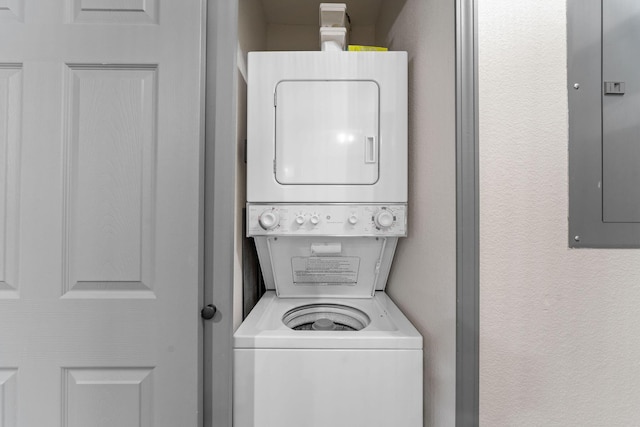 laundry room featuring stacked washer / drying machine and electric panel