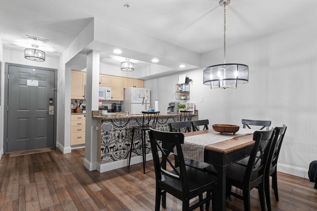 dining space featuring an inviting chandelier and dark hardwood / wood-style flooring