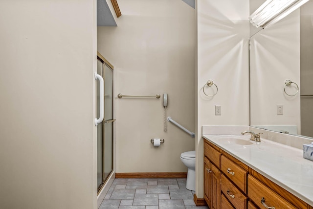 bathroom featuring a shower with door, vanity, and toilet