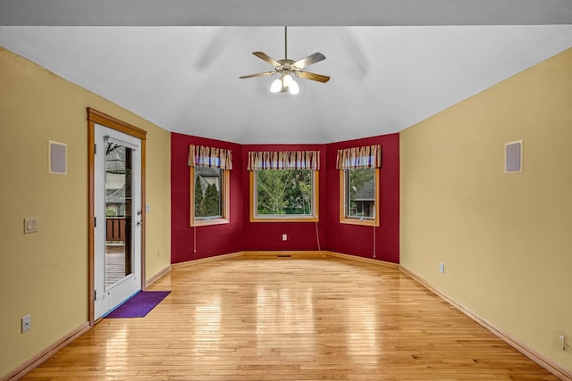 empty room featuring vaulted ceiling, light hardwood / wood-style floors, and ceiling fan