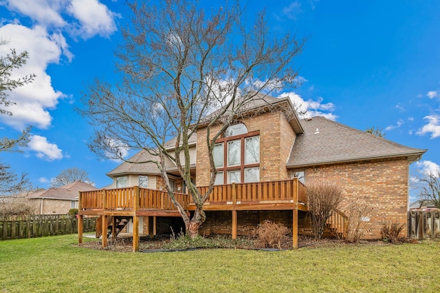 back of property featuring a wooden deck and a yard