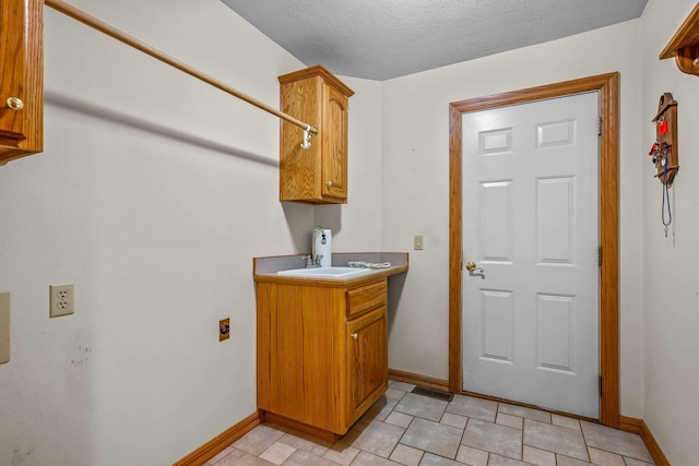 laundry room with hookup for an electric dryer, sink, and a textured ceiling