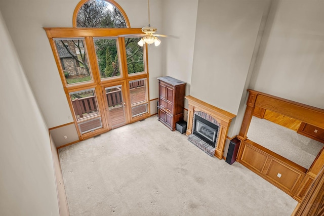 living room with a high ceiling, light colored carpet, and ceiling fan