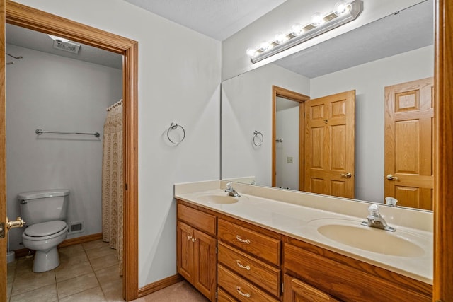 bathroom with tile patterned flooring, vanity, and toilet