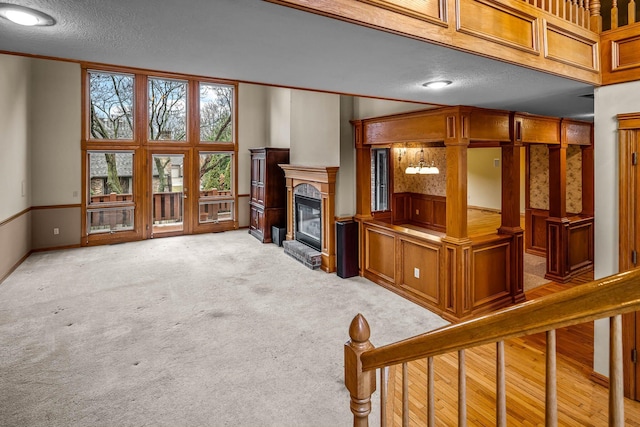 carpeted living room with ornamental molding and a textured ceiling