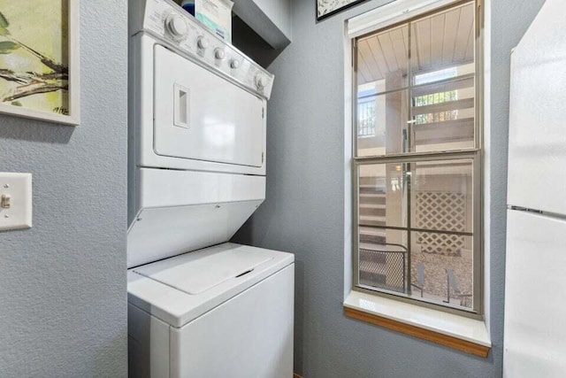 washroom featuring stacked washing maching and dryer