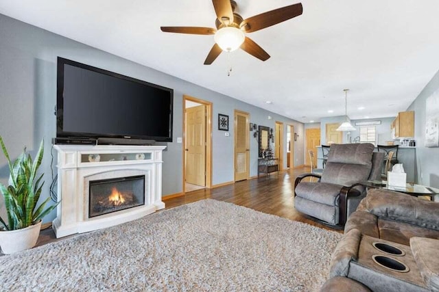 unfurnished living room featuring ceiling fan and dark hardwood / wood-style flooring