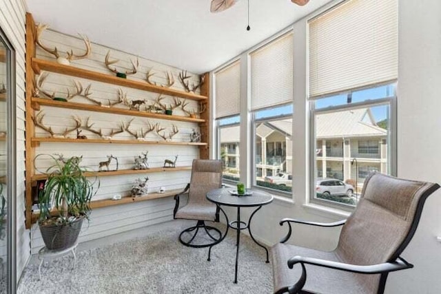 living area with carpet floors, a wealth of natural light, and ceiling fan