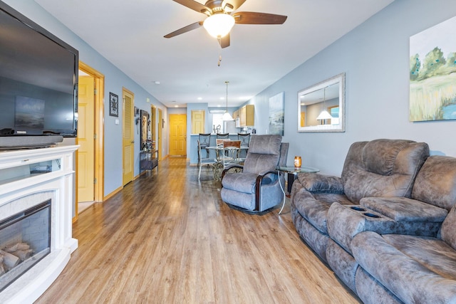 135 Upper Emerald Bay Cir Unit G-5, Hollister, MO 65672 - living room with ceiling fan, a glass covered fireplace, and light wood-style floors
