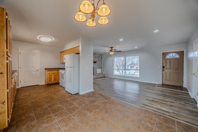 kitchen featuring white appliances, wood-type flooring, a fireplace, and ceiling fan with notable chandelier