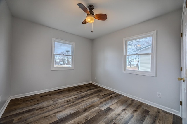 empty room featuring ceiling fan, plenty of natural light, and dark hardwood / wood-style floors