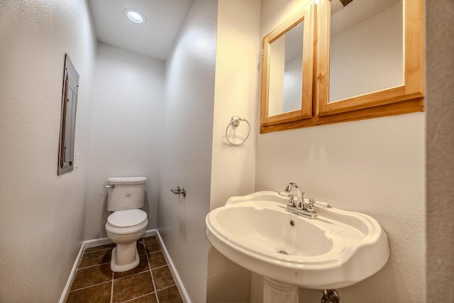 bathroom featuring toilet, tile patterned flooring, and sink