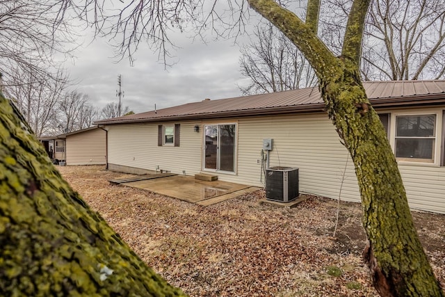 back of property with central AC unit and a patio area