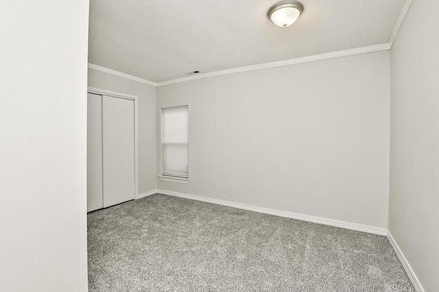 unfurnished bedroom with crown molding, carpet floors, and a closet