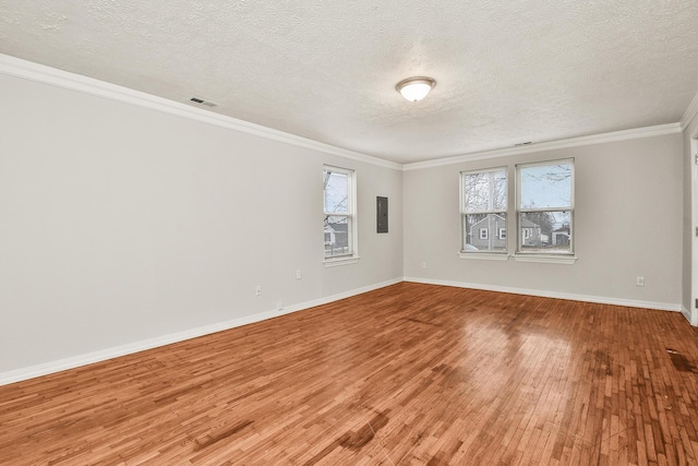 unfurnished room featuring hardwood / wood-style flooring, ornamental molding, electric panel, and a textured ceiling