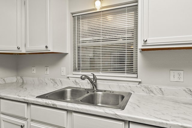 kitchen with white cabinetry and sink