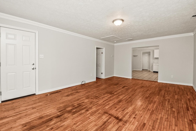 empty room featuring crown molding, light hardwood / wood-style floors, and a textured ceiling