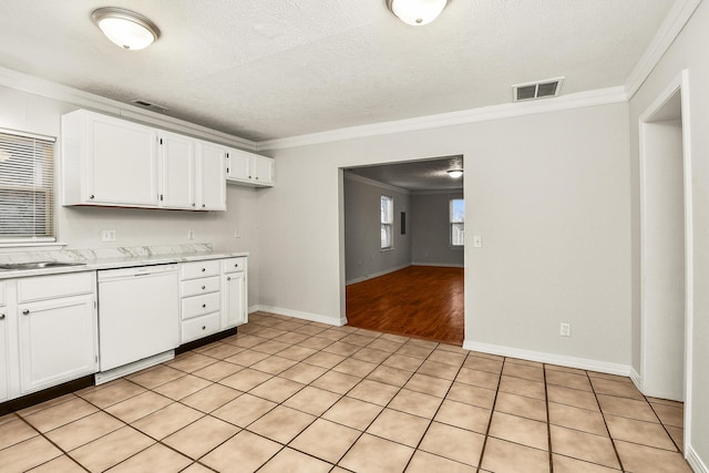 kitchen featuring white dishwasher, a textured ceiling, ornamental molding, and white cabinets