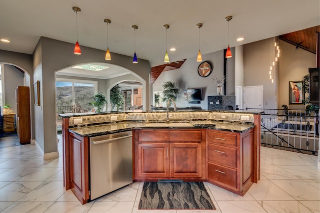 kitchen featuring pendant lighting, a kitchen island with sink, stainless steel dishwasher, and dark stone counters